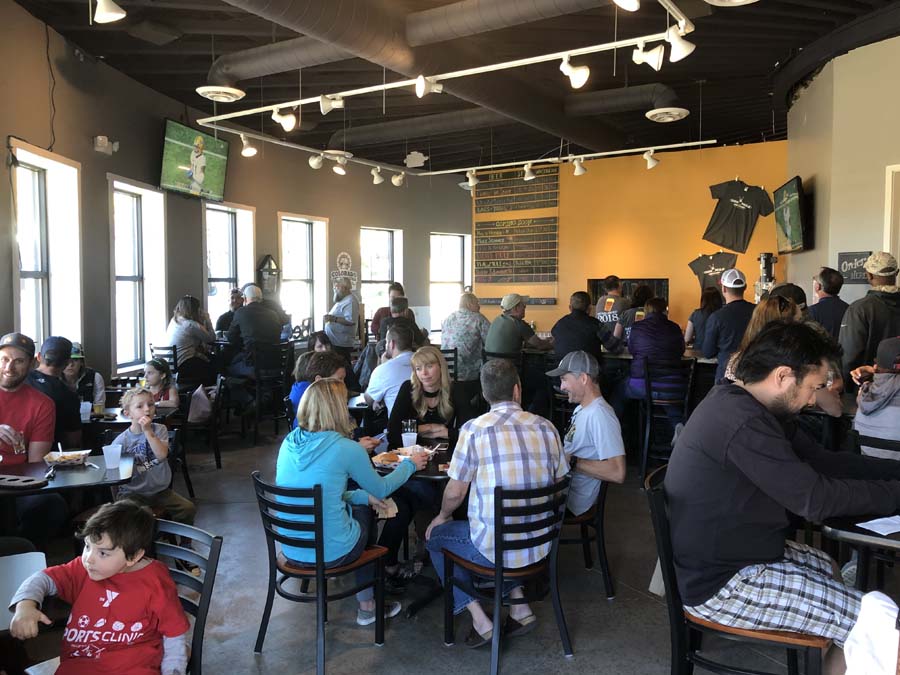 A large group of people are sitting at tables in a restaurant.