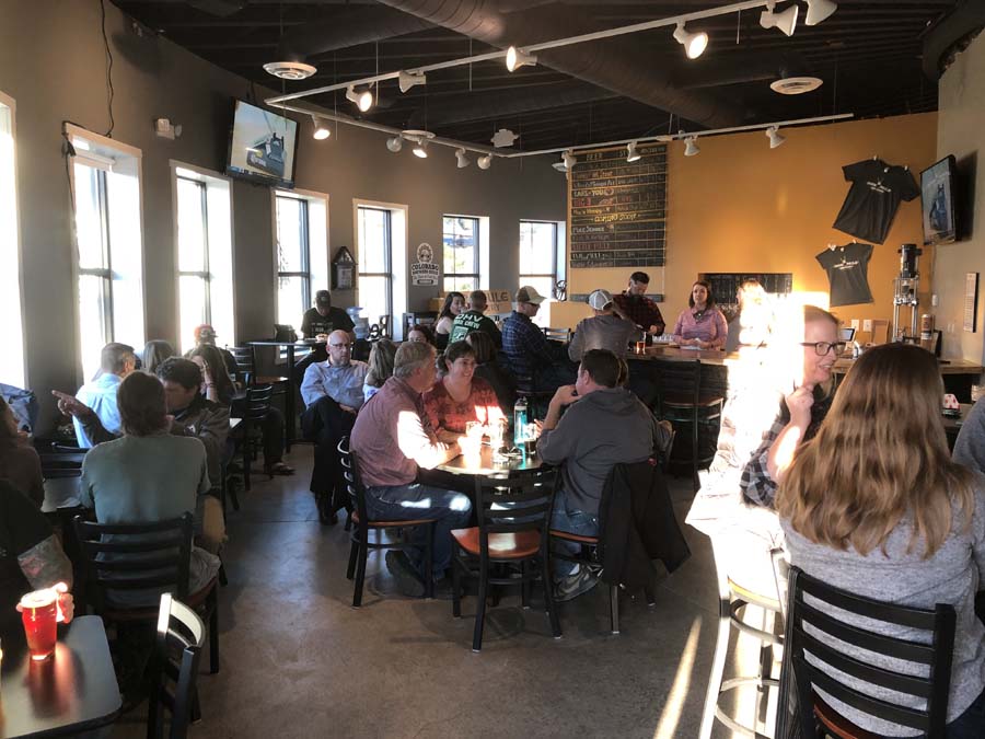 A group of people are sitting at tables in a restaurant.