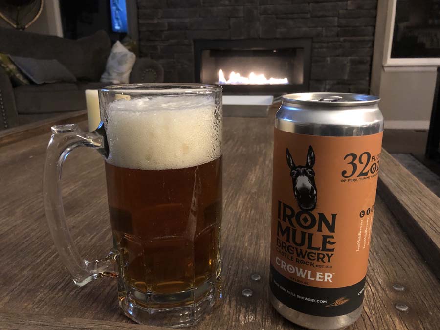 A can of iron mule brewery next to a glass of beer