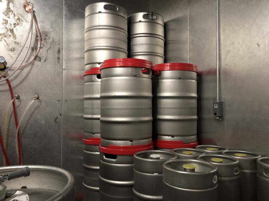 A bunch of kegs are stacked on top of each other