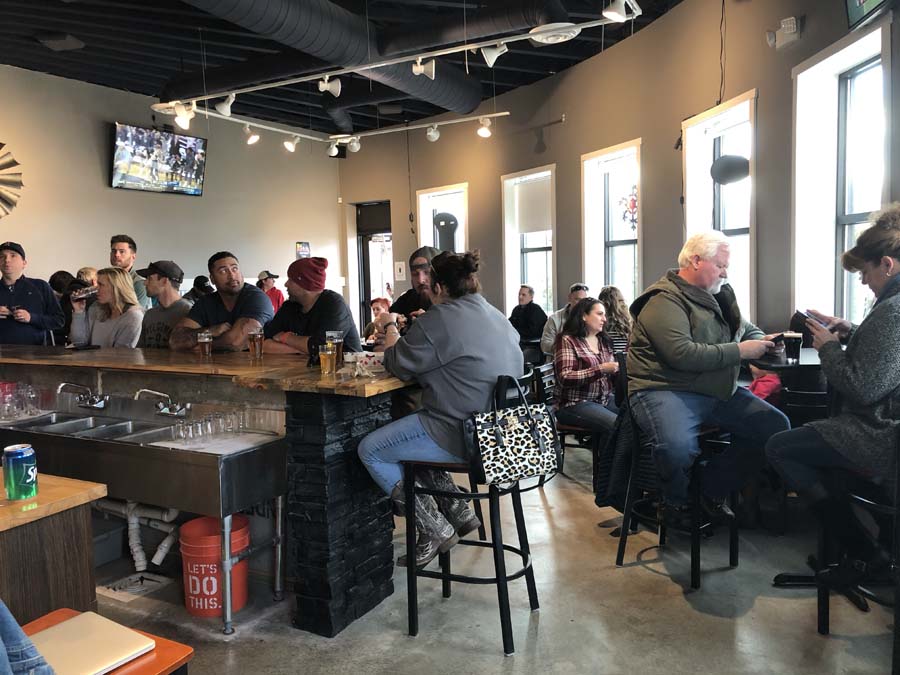 A group of people are sitting at tables in a restaurant.