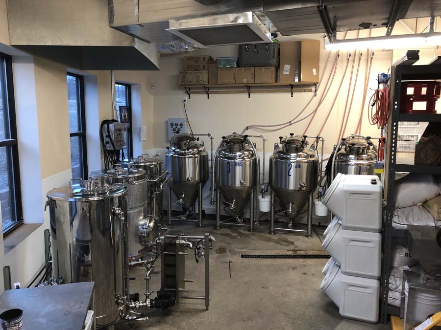 A room filled with lots of stainless steel tanks and containers.