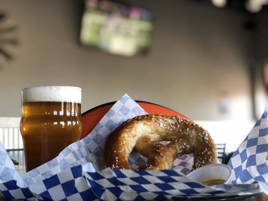 A pretzel and a glass of beer on a table