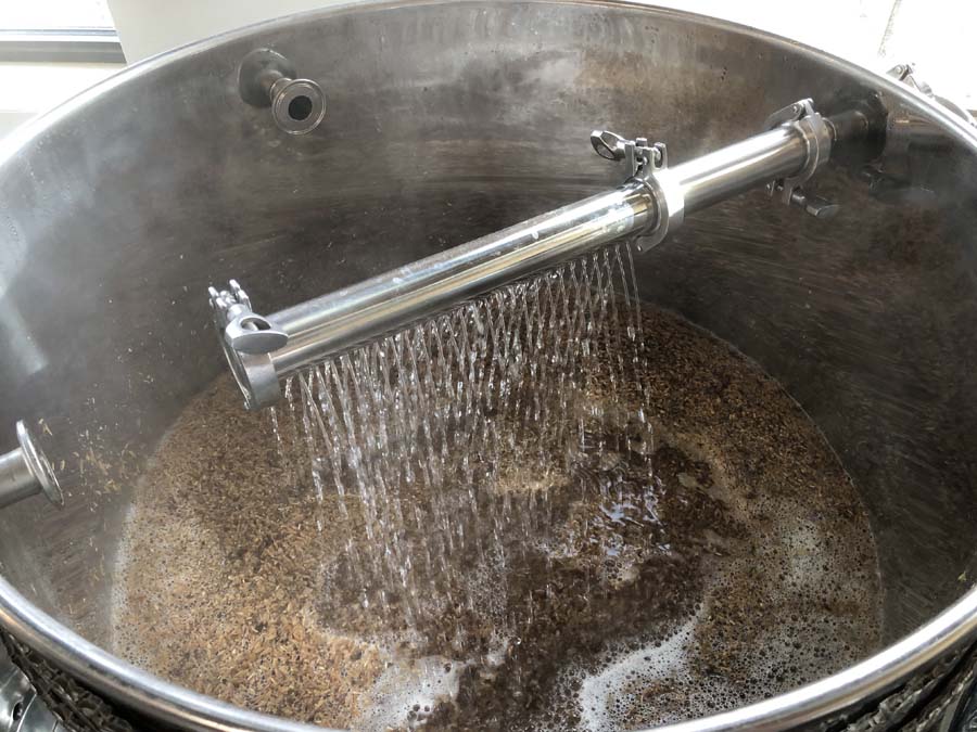A large stainless steel pot filled with brown liquid