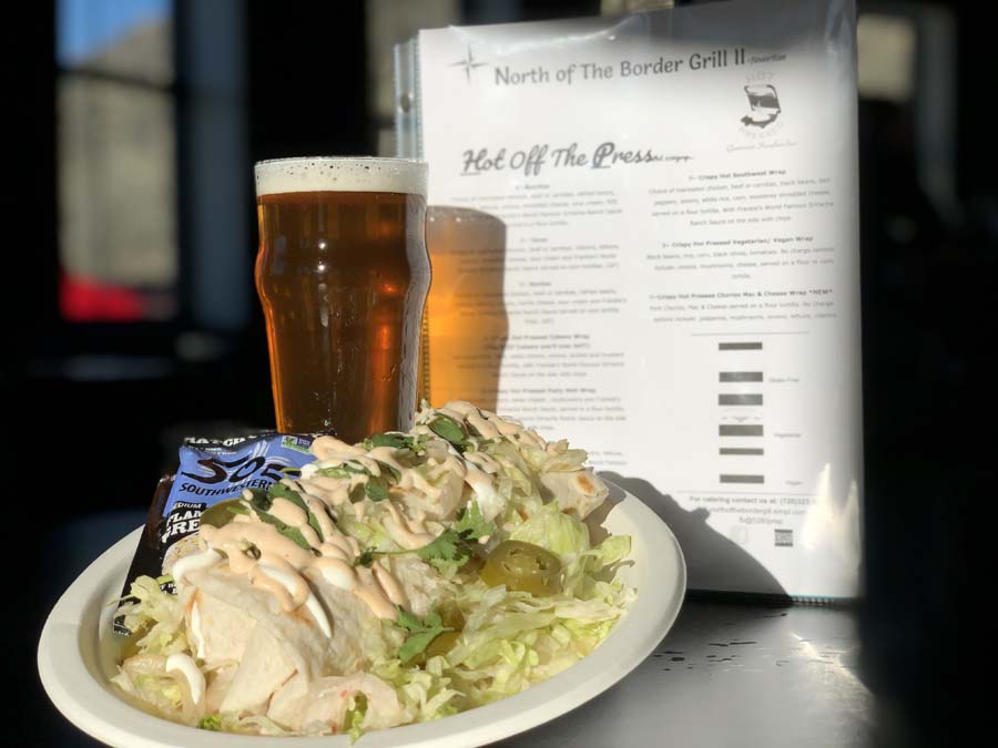 A plate of food and a glass of beer on a table.