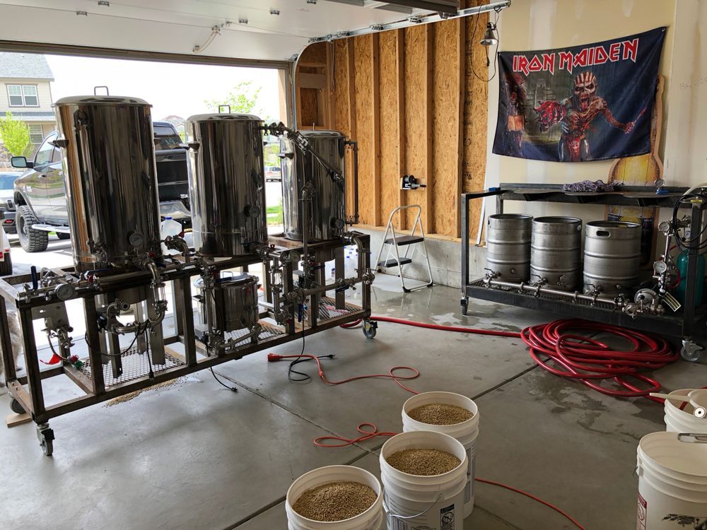 A brewery in a garage with a iron maiden flag hanging on the wall.