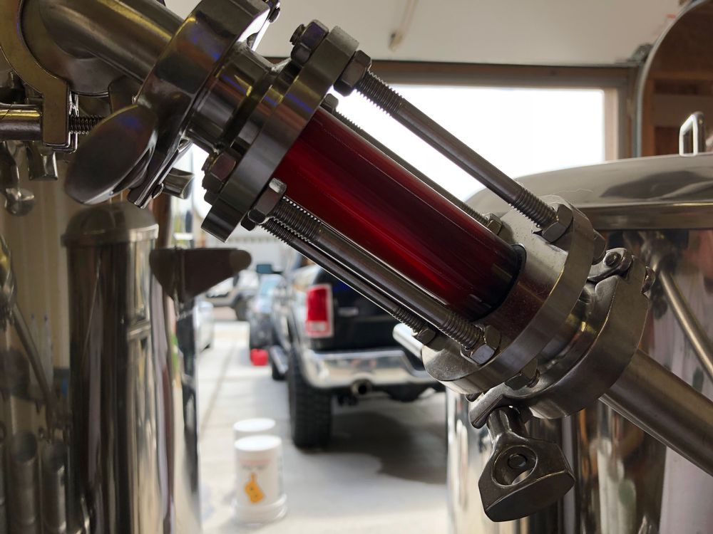 A stainless steel pipe with a red cylinder attached to it