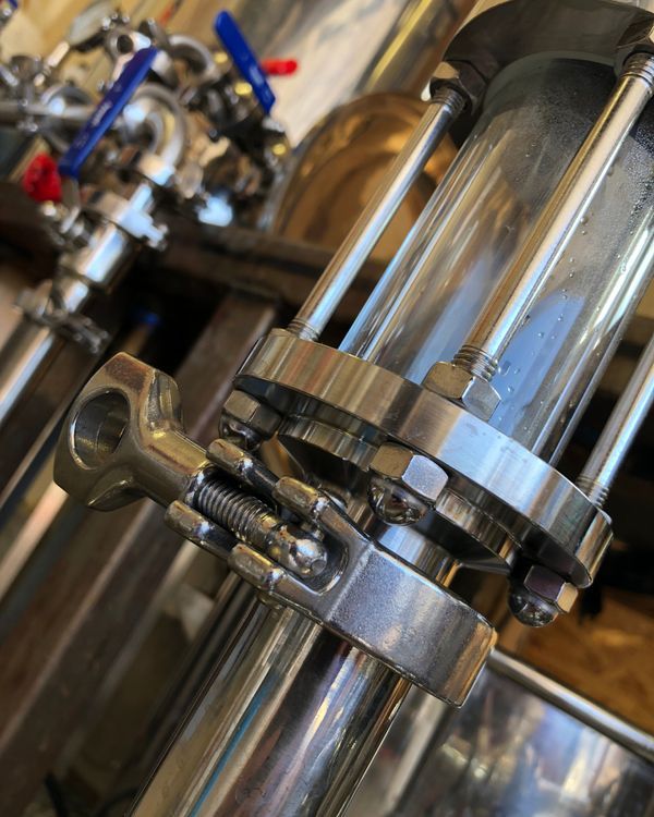 A close up of a metal pipe with nuts and washers