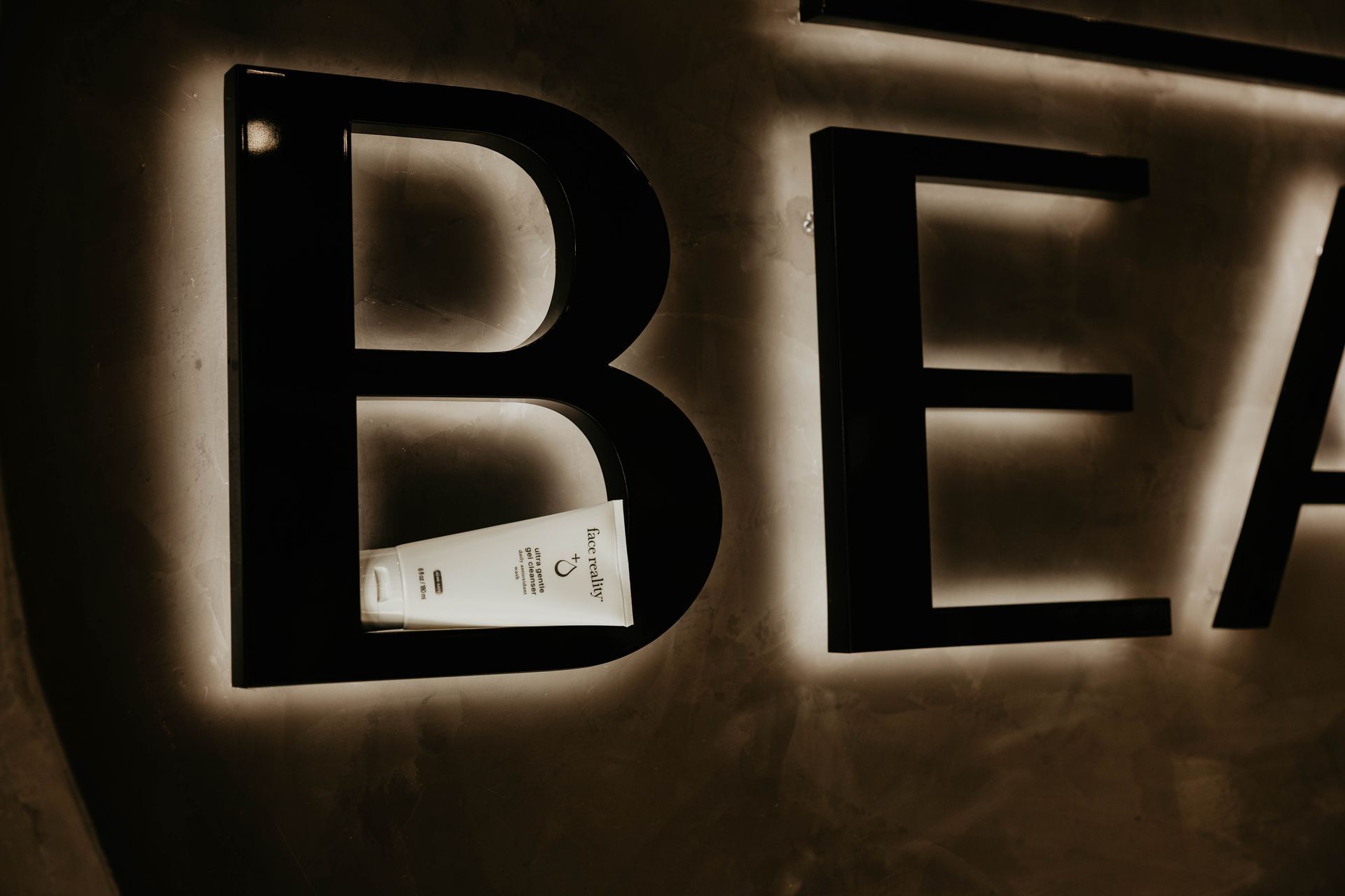 Lit-up sign: black letters spell 