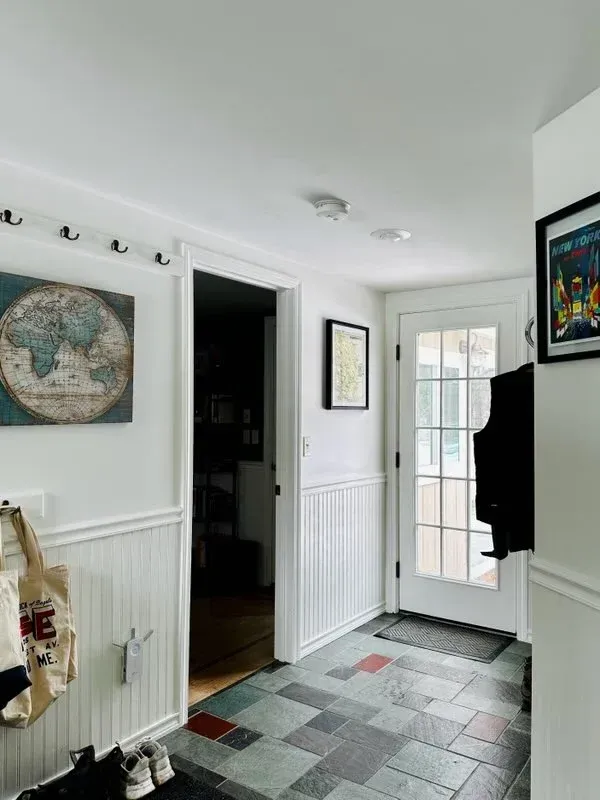 A hallway with a map on the wall and a door.