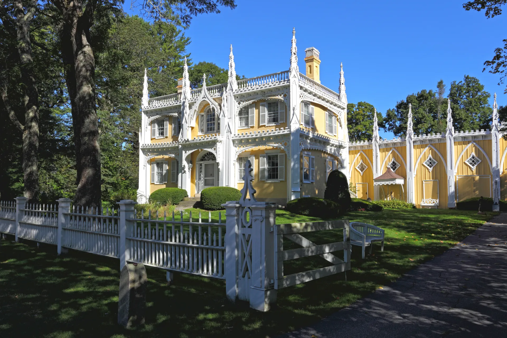 White two-story house with blue shutters and a front porch in a grassy yard