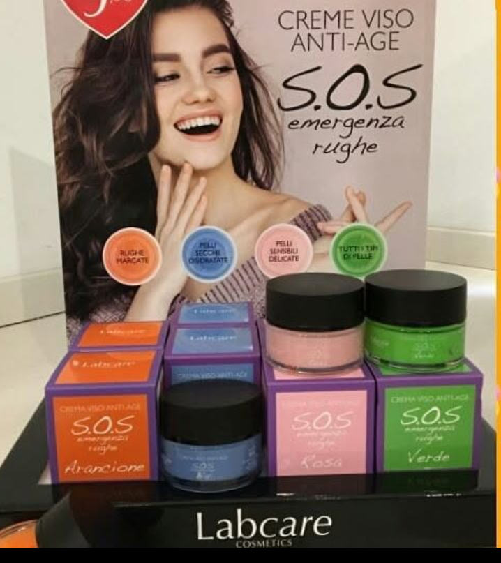Espositore per cosmetici con poster di una donna e vasetti di crema Labcare in confezioni arancioni, blu, rosa e verdi.