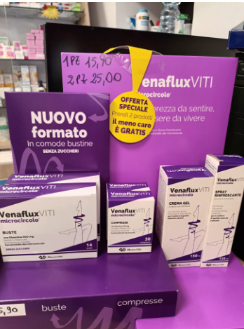 Vetrina illuminata di notte di una farmacia con insegna verde 