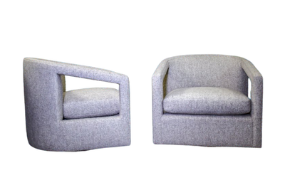 Two gray upholstered armchairs, one with a unique angled arm.