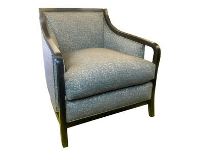 Gray speckled upholstered armchair with dark wood frame.