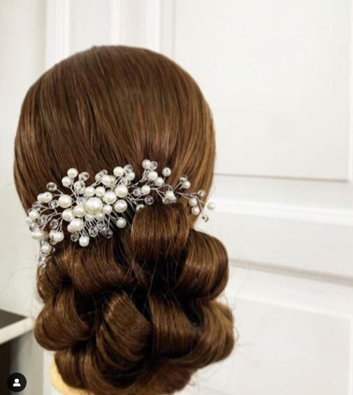 Acconciatura raccolta castana con fermaglio per capelli di perle e cristalli.