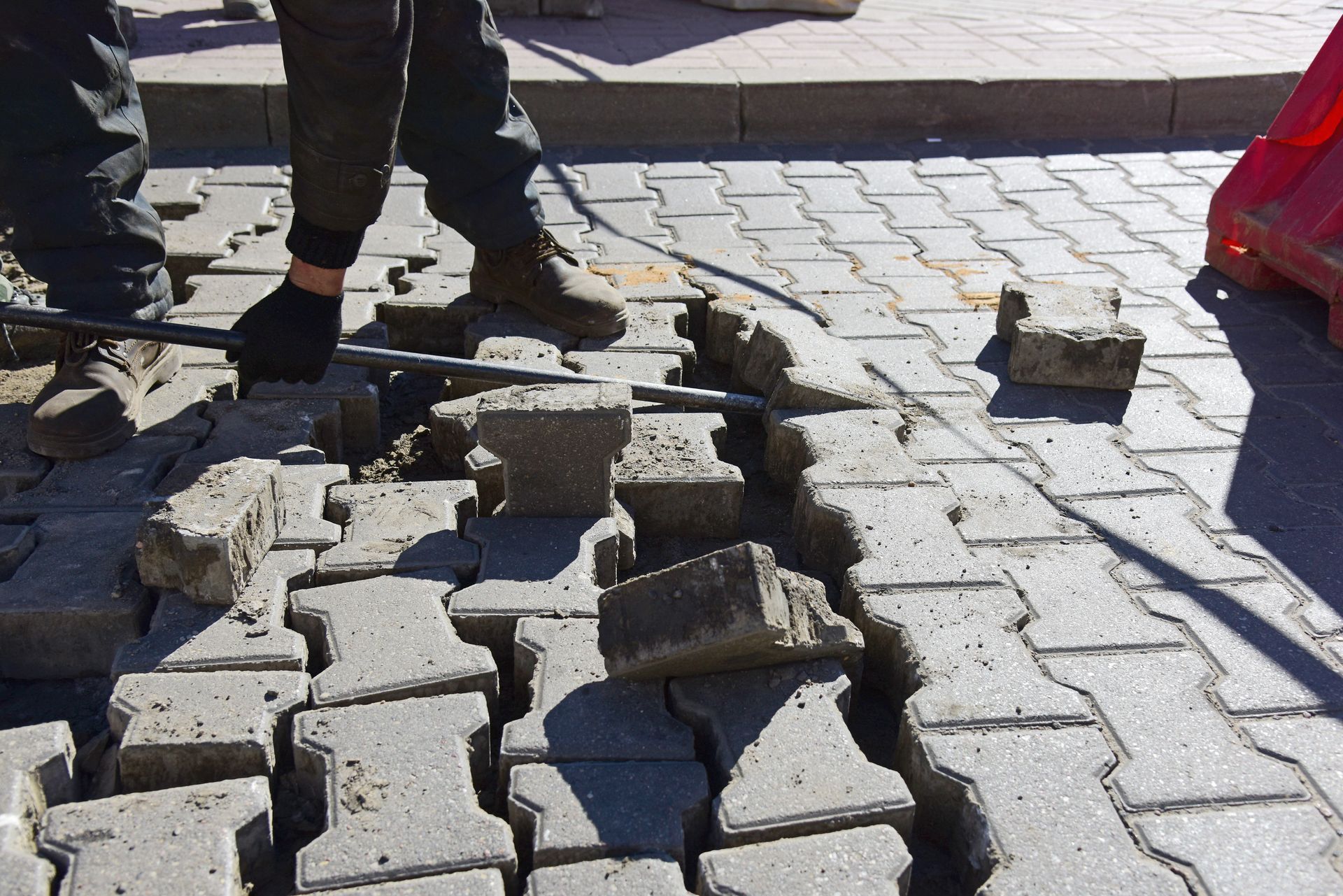 Slab Repair - Damaged pavement with broken concrete blocks and two people’s legs standing nearby - Savannah, GA