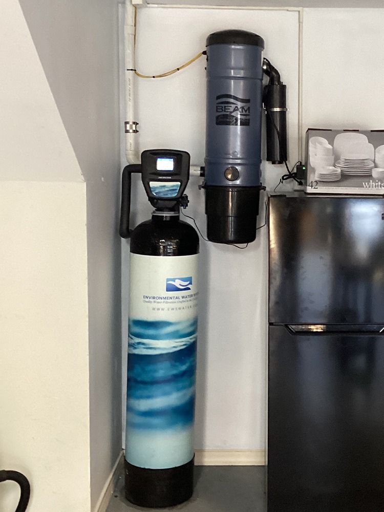 Water Filtration Systems -Two water softener/filter tanks with a control head beside a refrigerator in a small utility nook - Savannah, GA