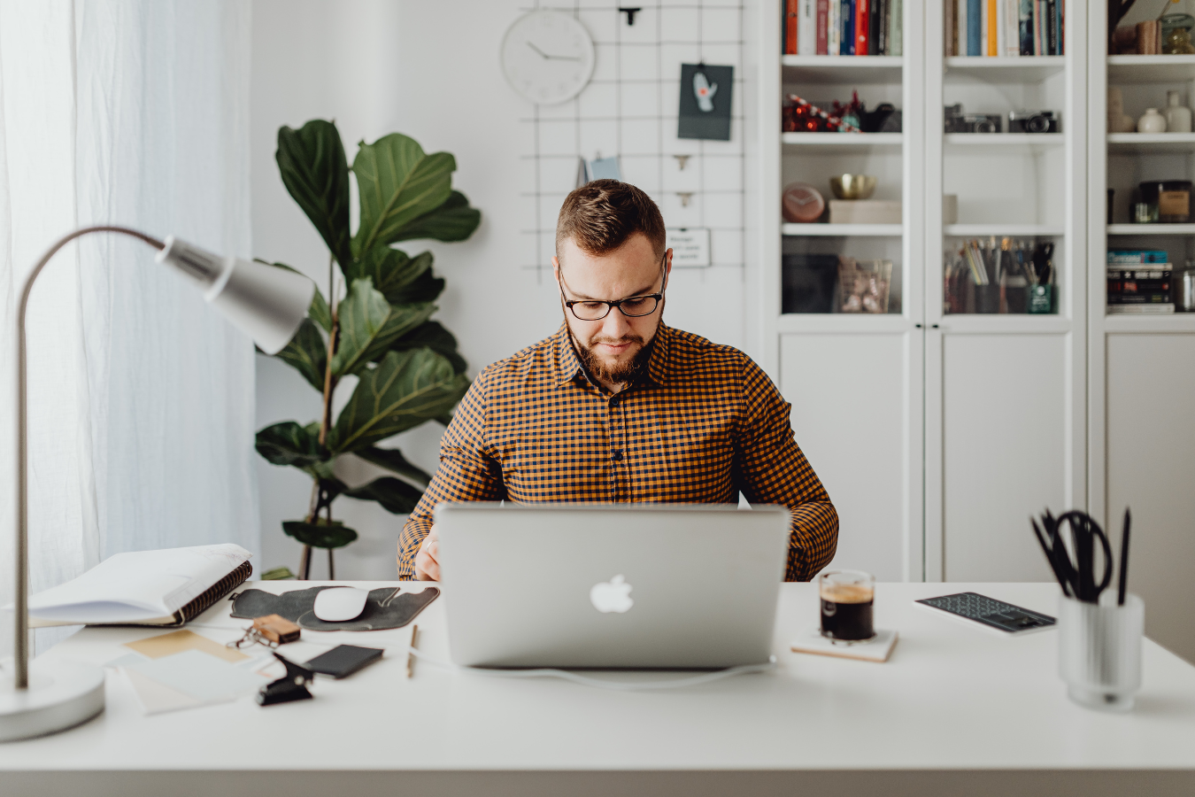 A man is sitting at a desk using a laptop computer.