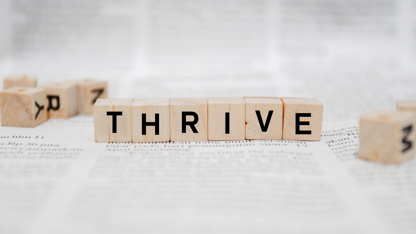 the word thrive is written on wooden blocks on a bible