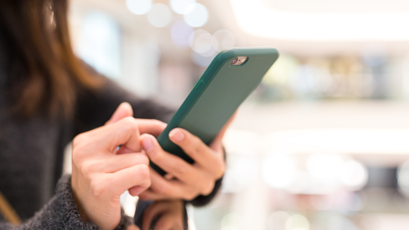A woman is holding a cell phone in her hands.