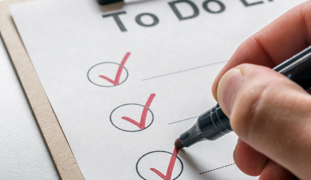A person is writing on a to do list with a marker.