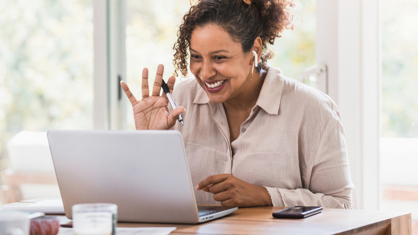 A woman is sitting at a table using a laptop computer.