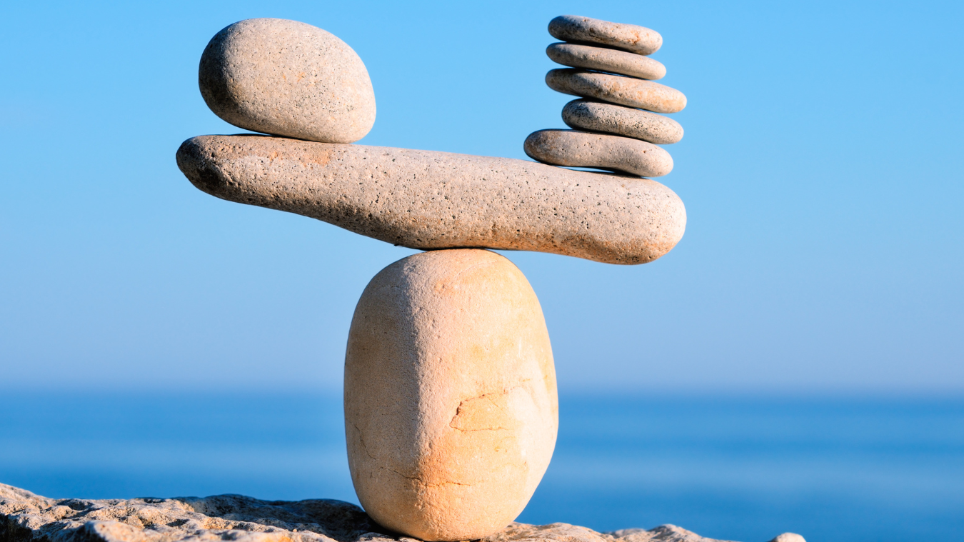 A stack of rocks sitting on top of each other on a rock near the ocean.