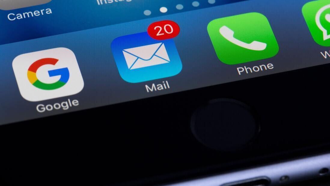 A close up of a cell phone displaying the google mail and phone apps.