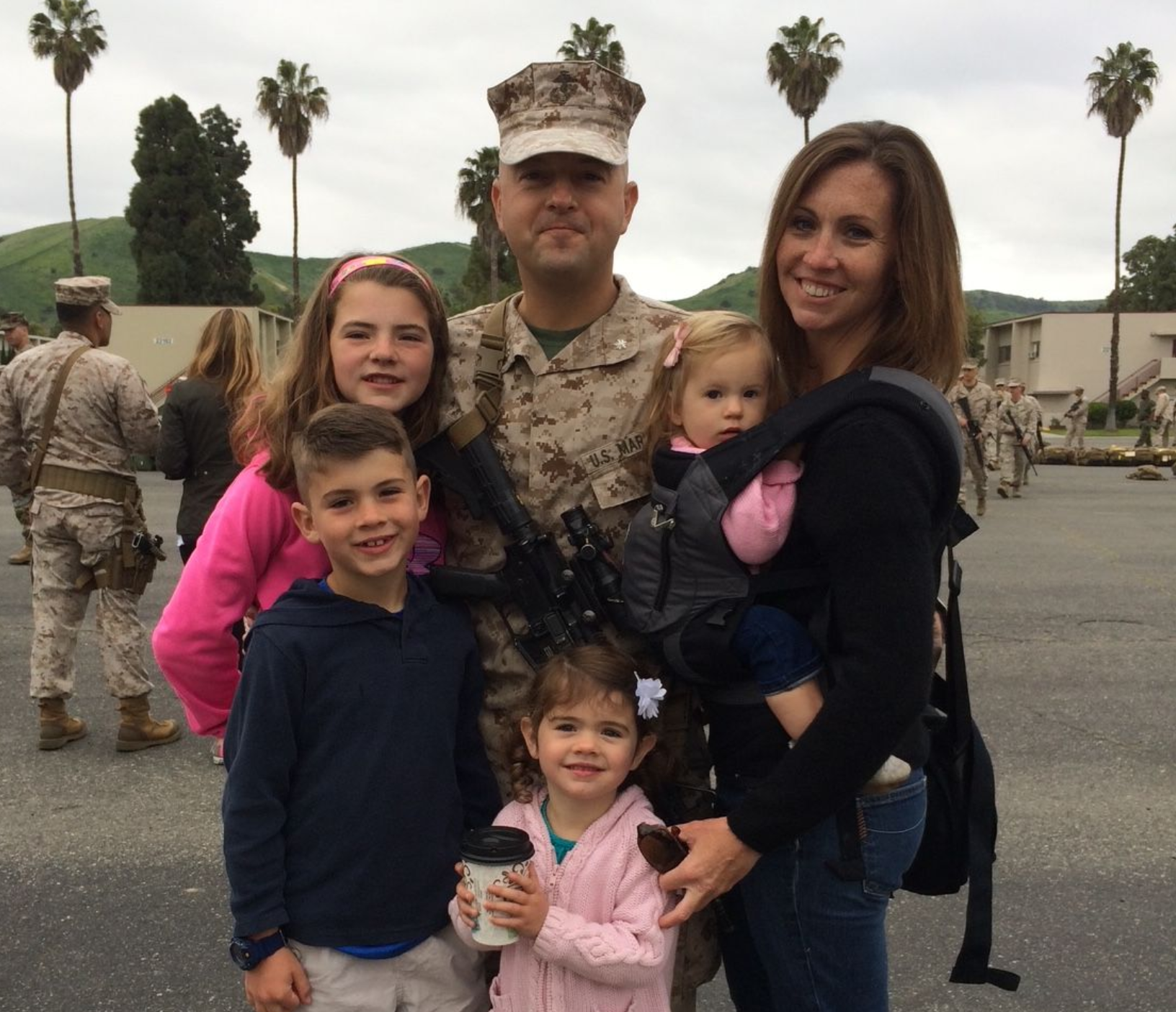 a man in a military uniform poses with his family