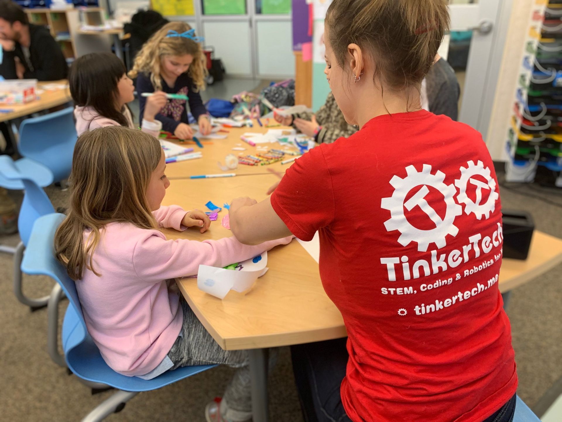 TinkerTech camp counselor helps girl with project