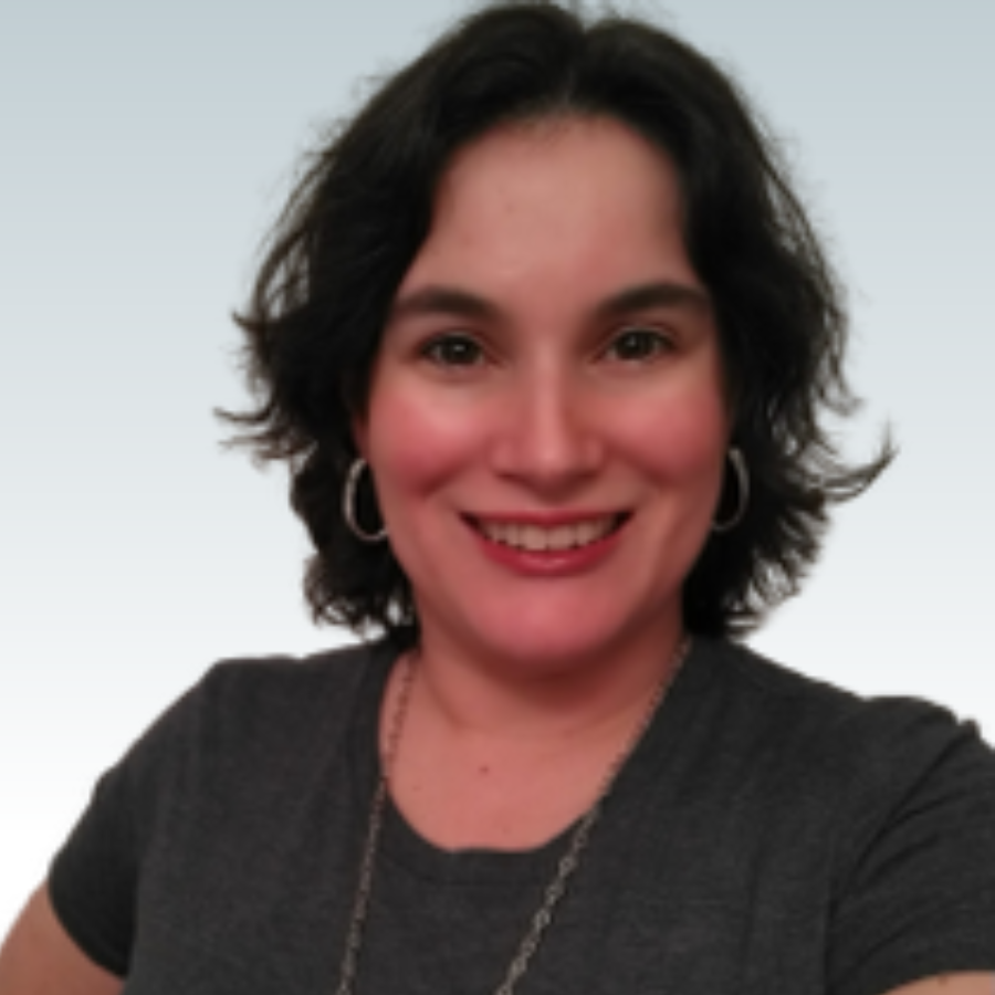A woman wearing a grey shirt and hoop earrings smiles for the camera