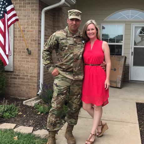 a man in a military uniform is standing next to a woman in a red dress