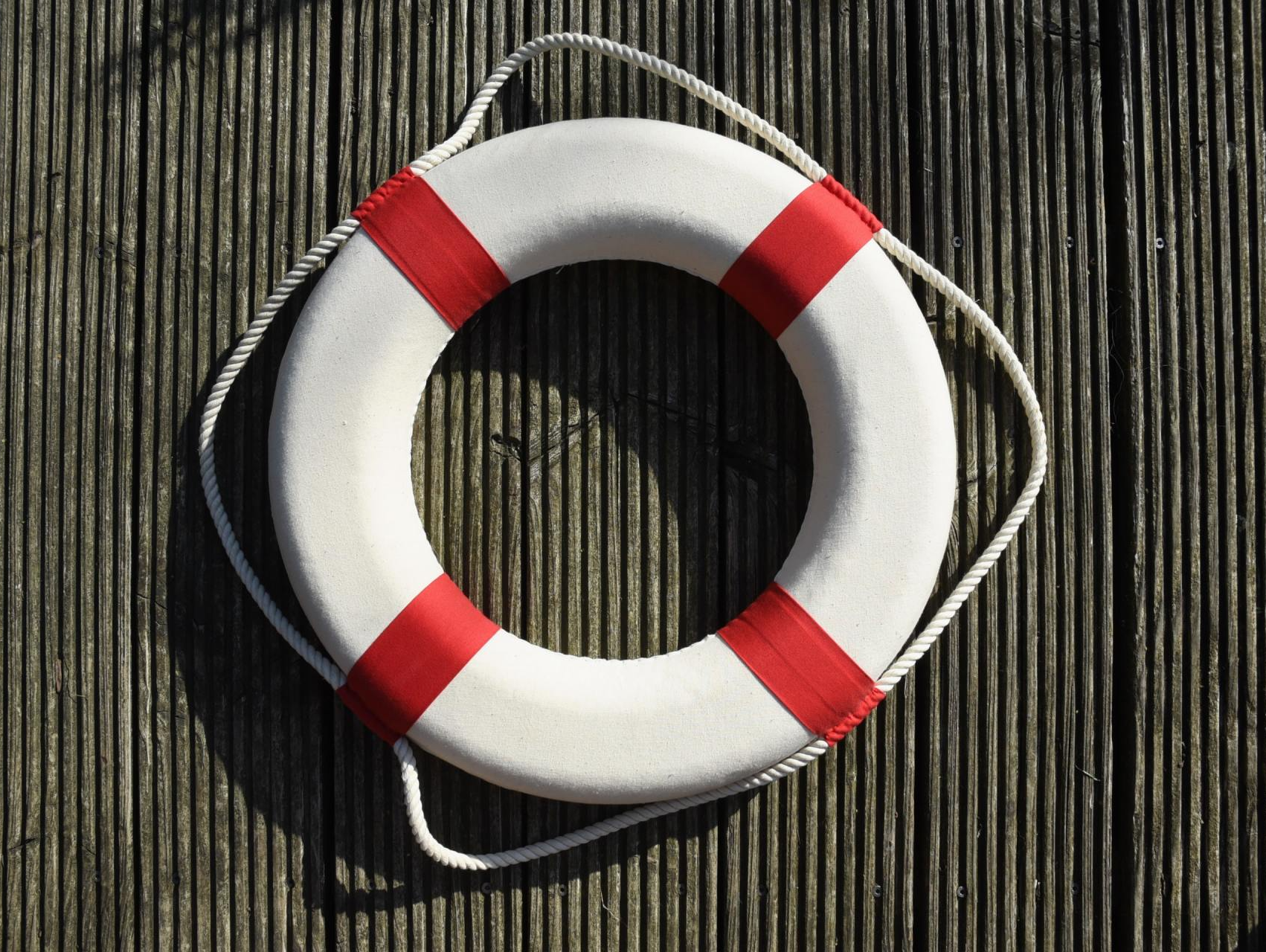 white and red lifesaver against a wood background
