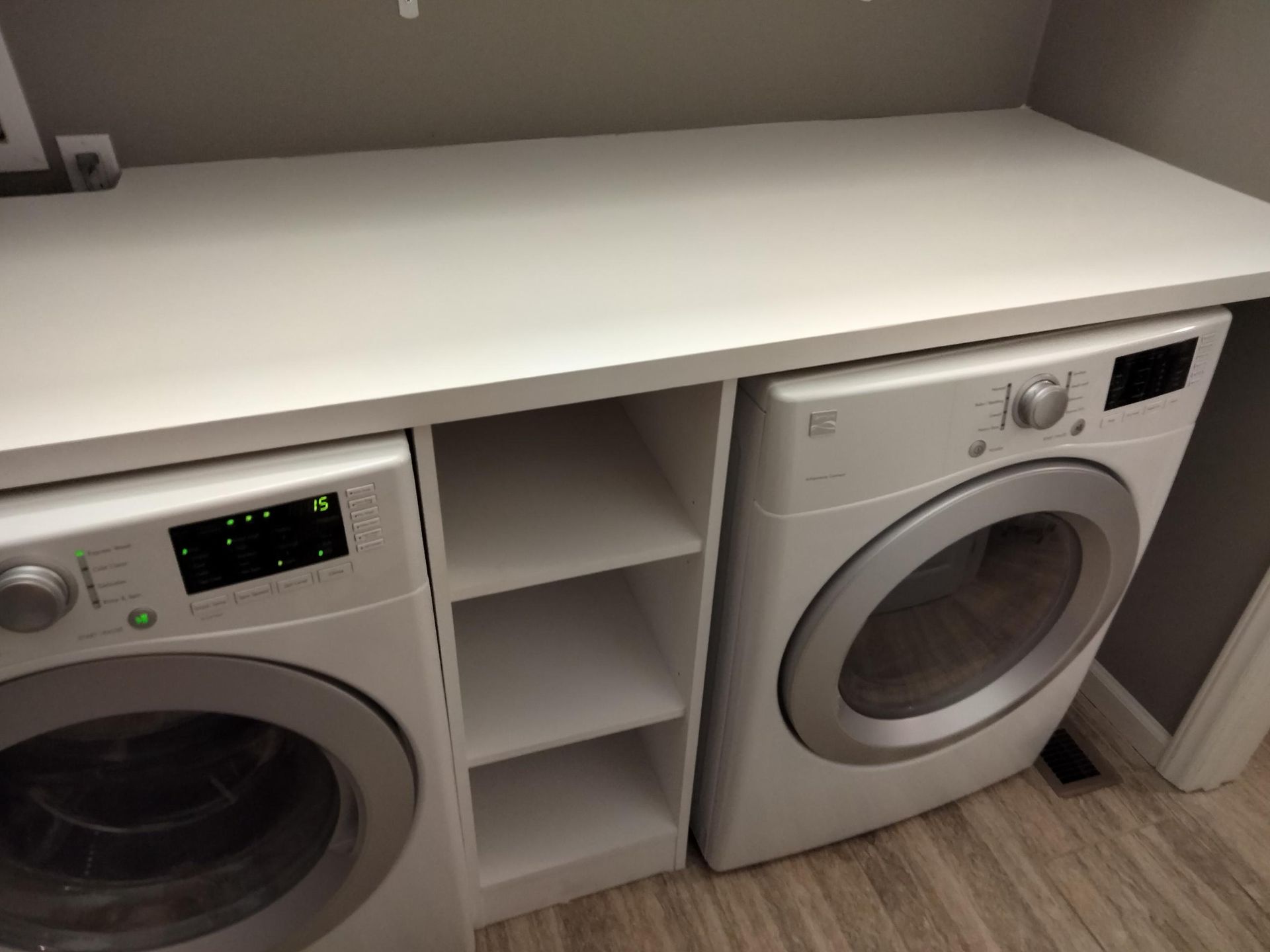 A laundry room with a washer and dryer on a counter.