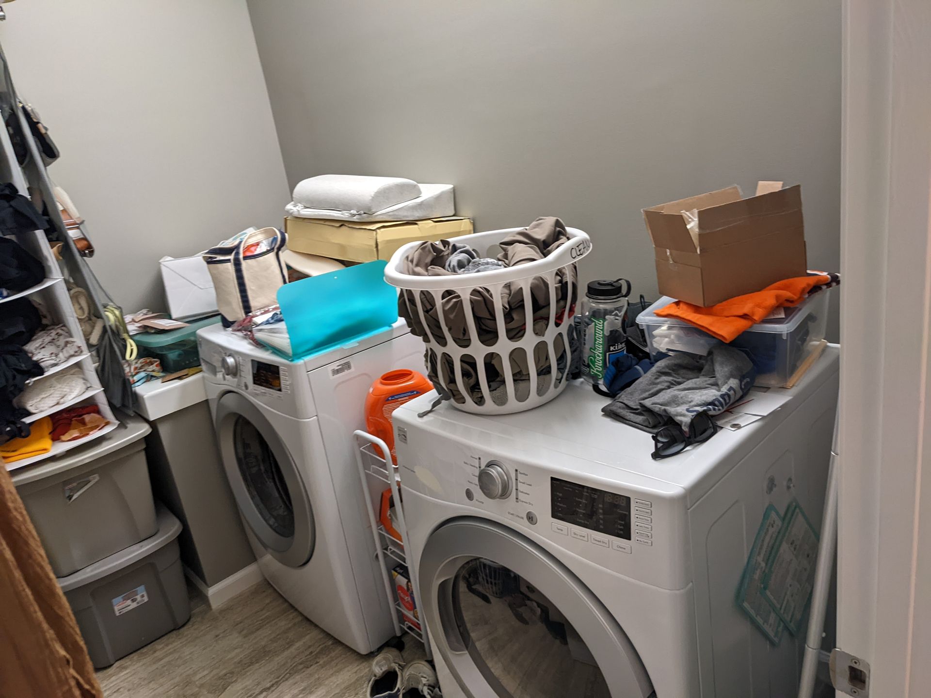 A laundry room with a washer and dryer and a basket of clothes.