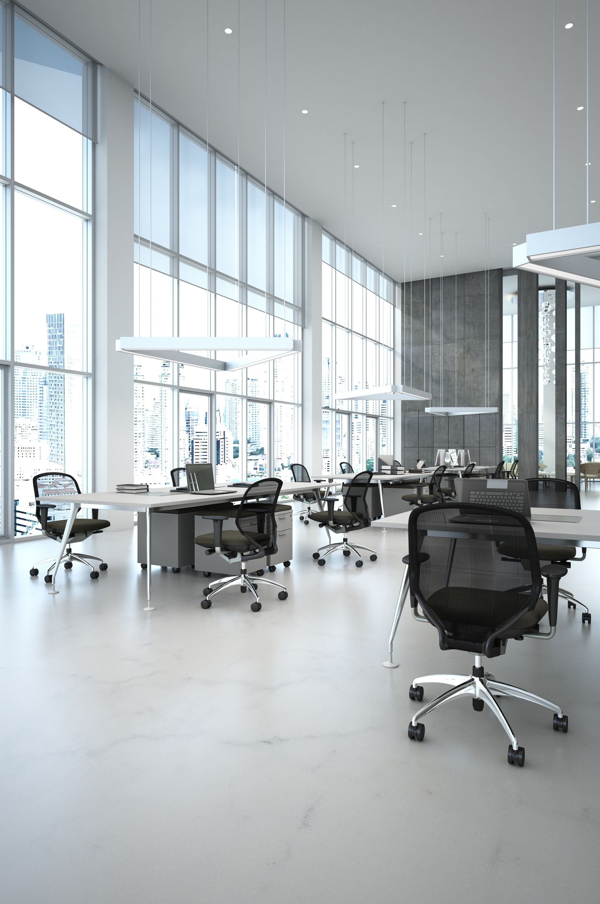 An empty office with a lot of windows and tables and chairs.