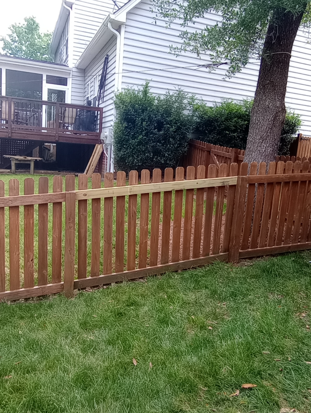 There is a wooden fence in the backyard of a house.