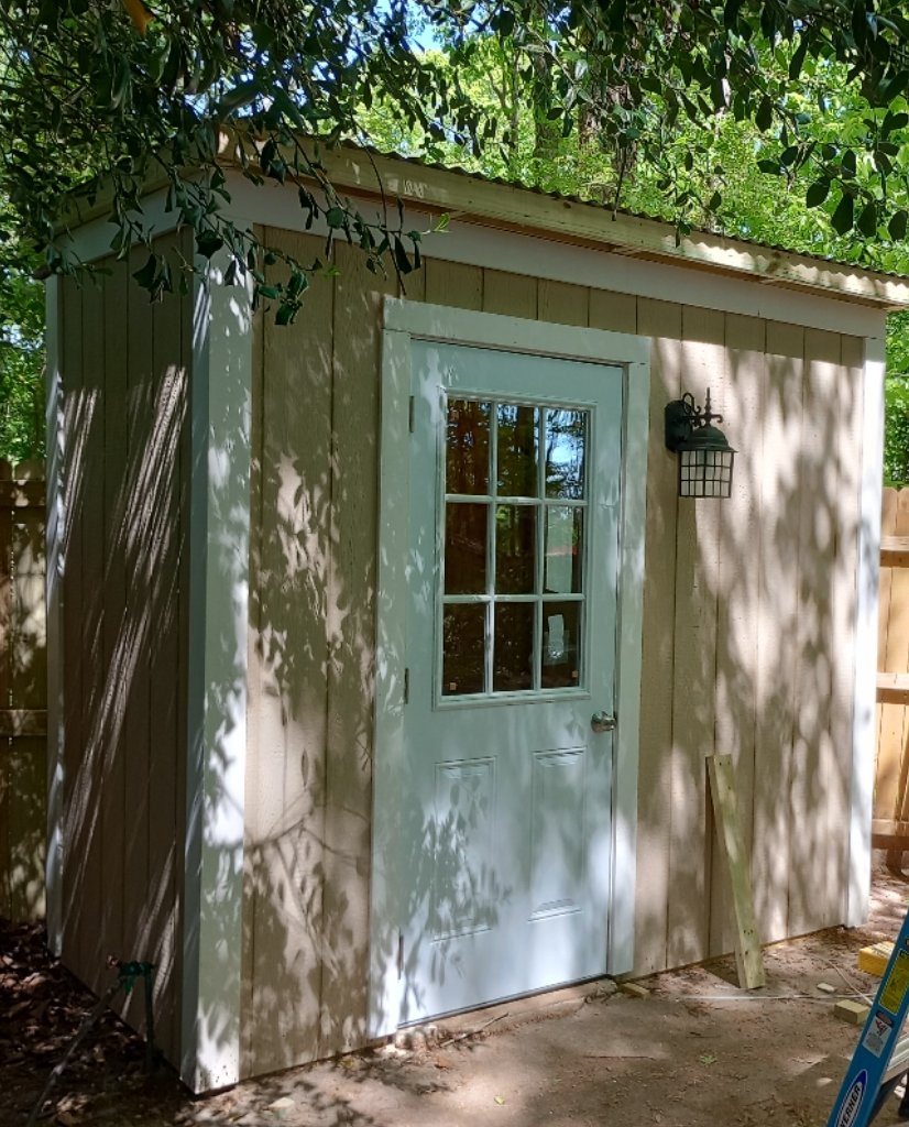 A small shed with a white door and a window.