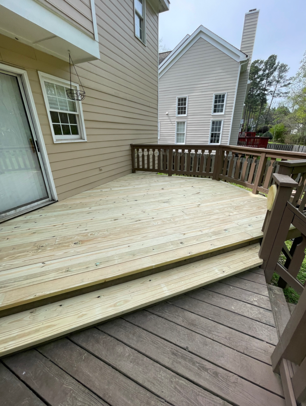 A wooden deck is sitting in front of a house.