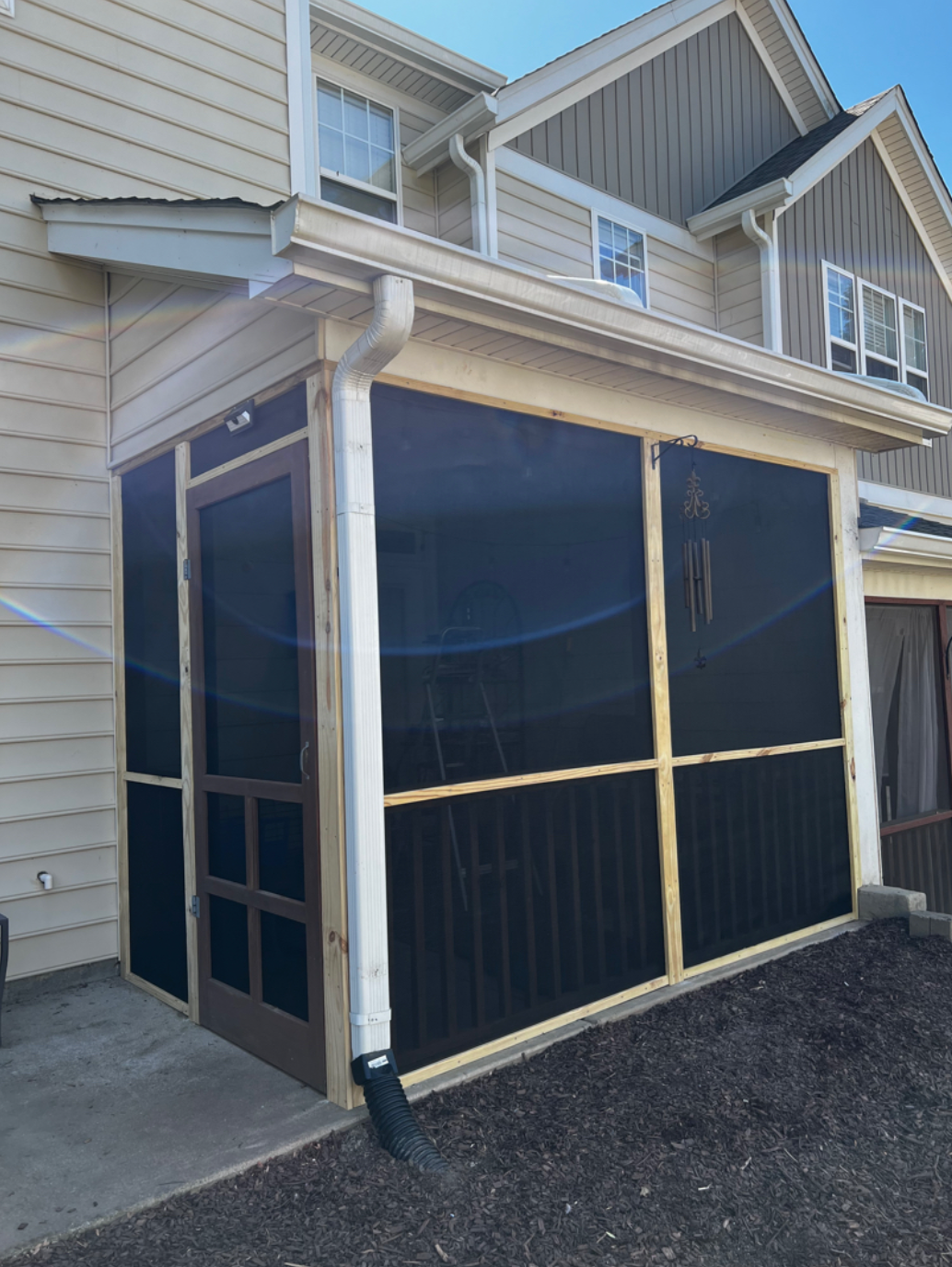 A screened in porch on the side of a house
