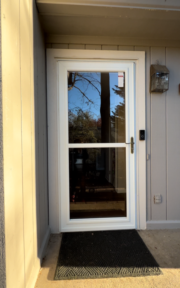 A white door with a black mat in front of it