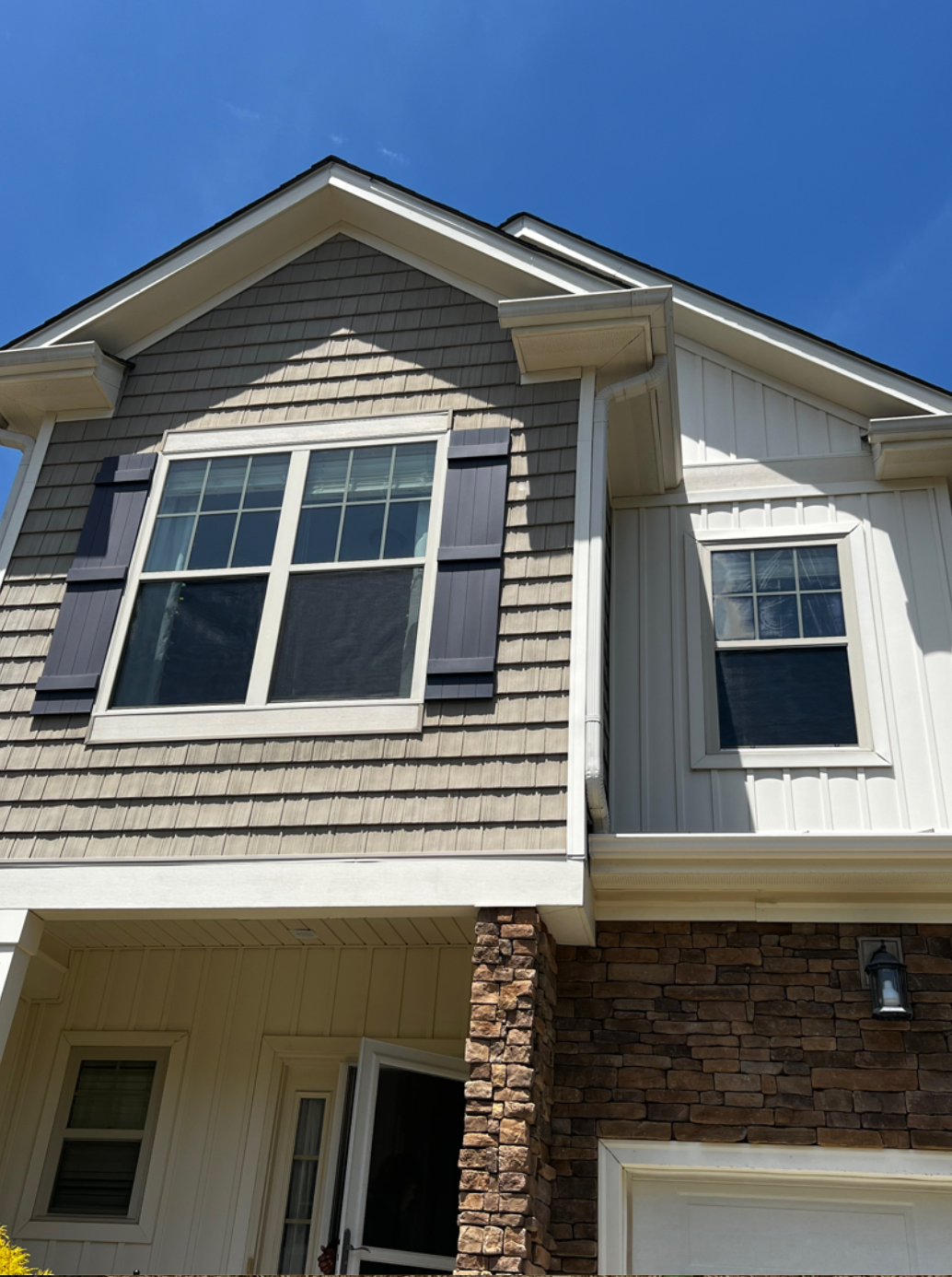 A house with a lot of windows and a blue sky in the background