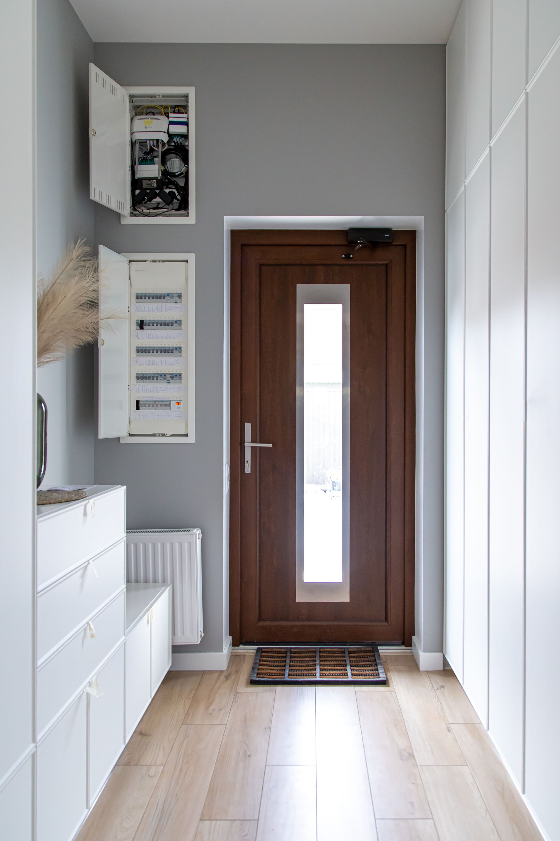 A hallway with a wooden door and a window.