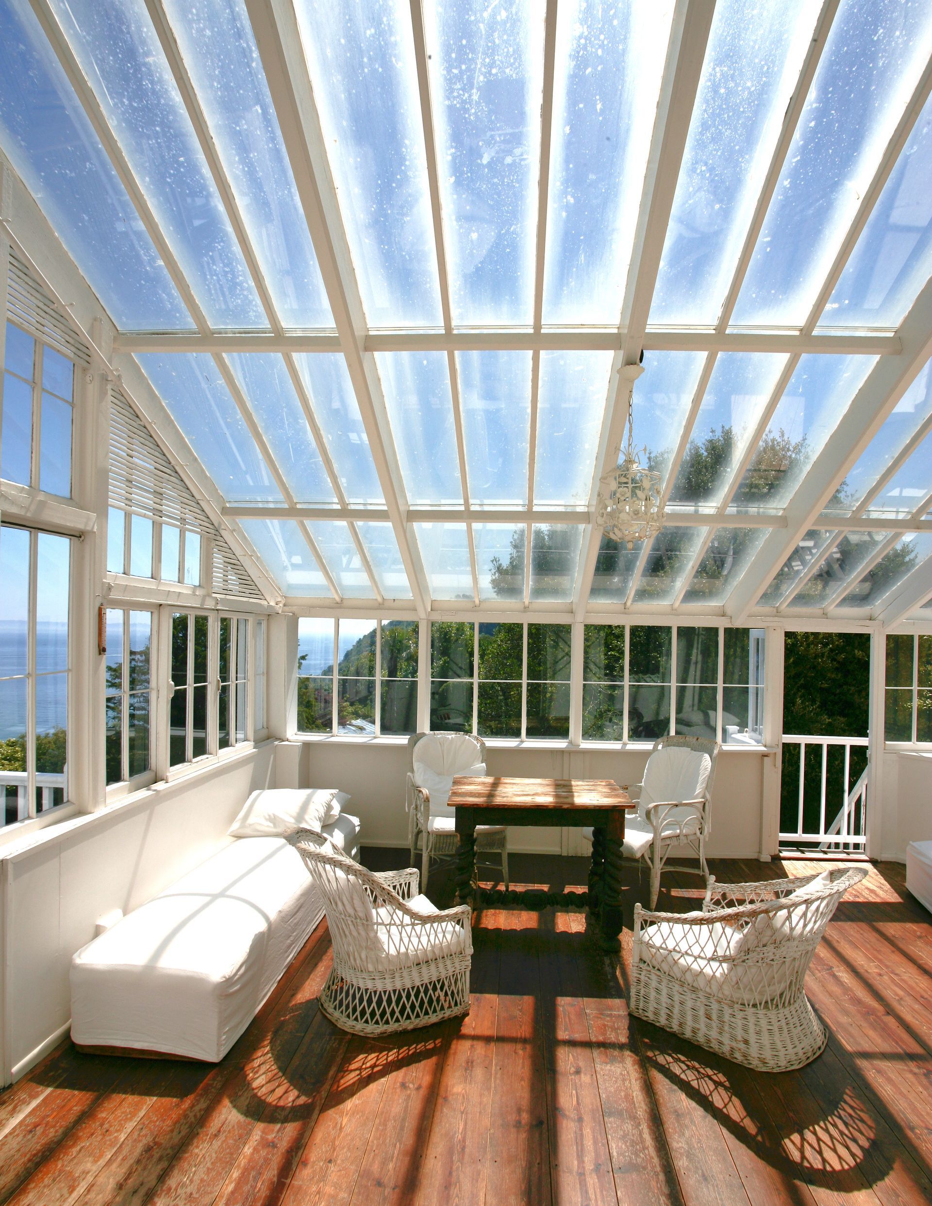 A living room with a table and chairs under a glass roof