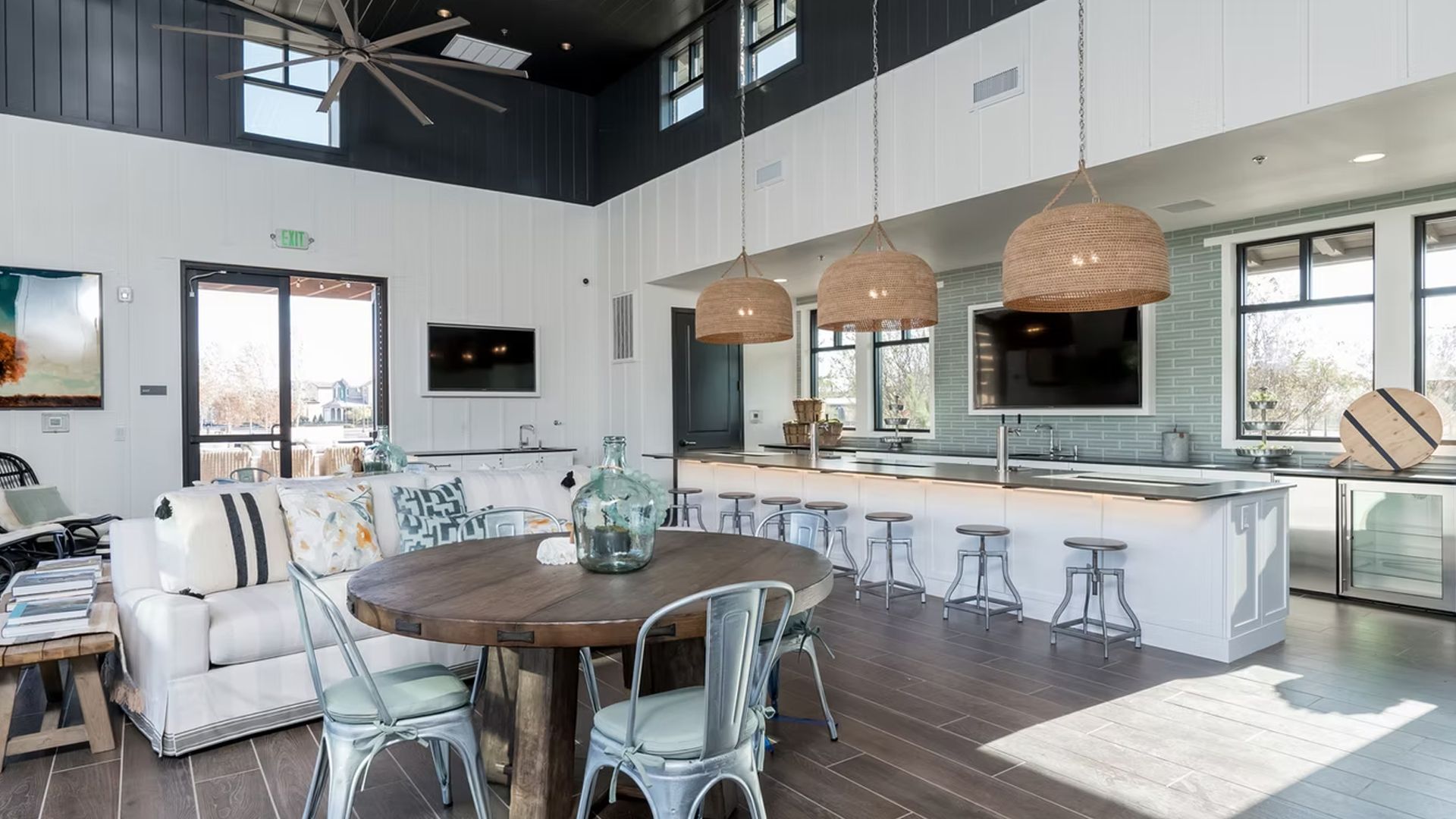Open-plan kitchen and living room with a large island, round table, and white sofa. Brown and blue accents.