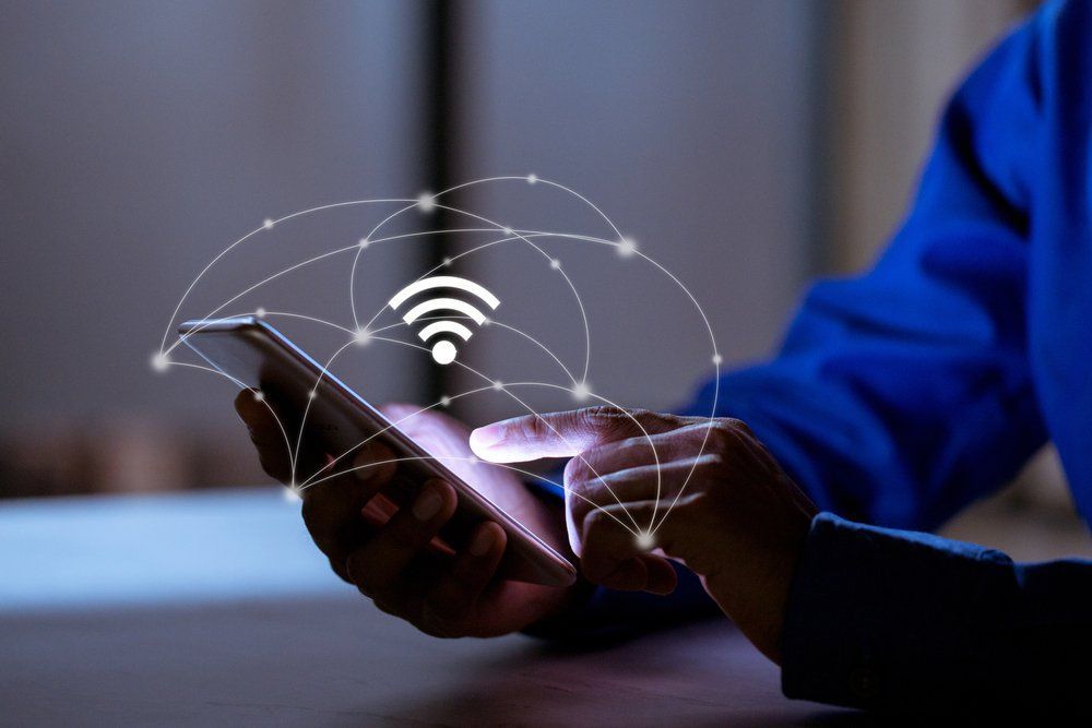 Person Holding Phone With Wifi Symbol And Network Lines — Superior Wifi in East Ballina, NSW