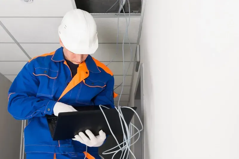 Construction Worker in Blue and Orange Uniform and White Hard Hat Examines a Laptop — Superior Wifi in Lennox Head, NSW