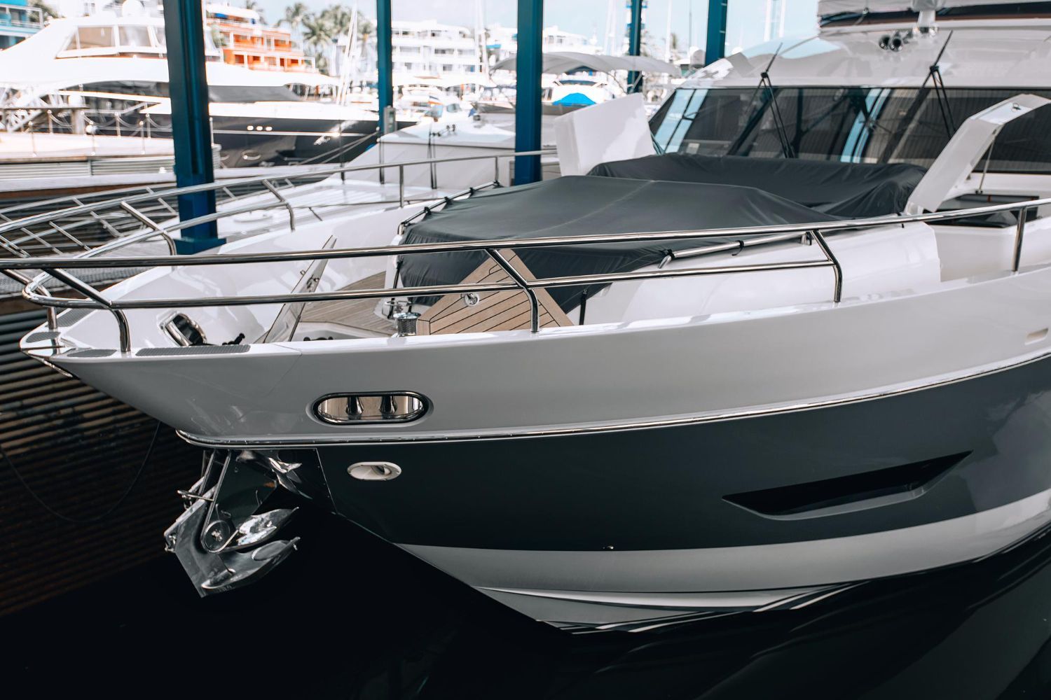 White luxury yacht docked at a marina, showing the bow and metal railing.