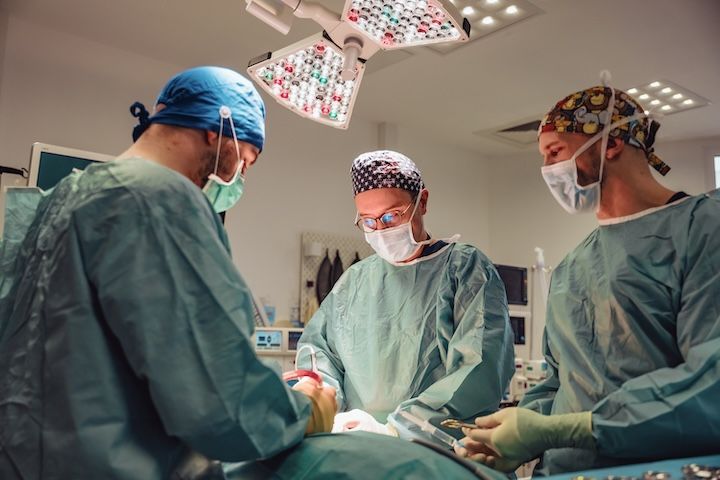 Un groupe de chirurgiens opère un patient dans une salle d'opération.